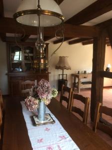 a dining room with a table with a vase of flowers at Gîte Les Chotzi's in Maennolsheim
