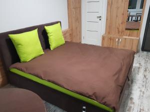 a bed with two green pillows on it in a room at Silver Star Apartment 40b in Uzhhorod