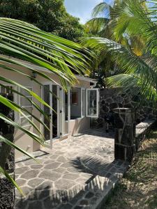 a patio of a house with a palm tree at Whynot Mauritius in Grand Gaube