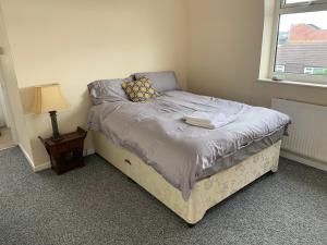 a small bed in a room with a window at Nice double and single rooms in the quiet area with excellent shared facilities in Plymouth