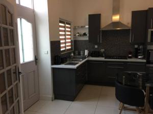 蒂耶里堡的住宿－duplex agréable et calme，厨房配有黑色橱柜、水槽和桌子