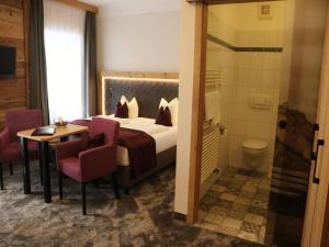 pokój hotelowy z łóżkiem, stołem i krzesłami w obiekcie Hotel Stegerbräu w mieście Radstadt