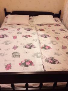 a bed with a floral comforter on it at Idyllinen kaksio in Kankaanpää