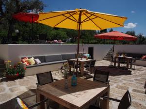 a patio with a table and a yellow umbrella at Casa Branca in Covas