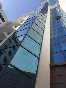 un edificio alto con ventanas de cristal azul en New apartment in new building, en Samarkand