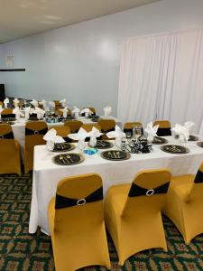 um grupo de mesas e cadeiras com toalhas de mesa brancas em Budget Inn & Suites - Talladega em Talladega