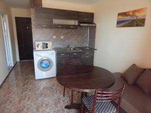 a kitchen with a table and a washing machine at Dunav Apt.2 in Ravda +9 photos