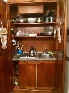 una cucina con lavandino e bancone con pentole e padelle di Grangia in borgo antico a Bardonecchia