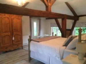a bedroom with a large bed and a wooden cabinet at Chez Broche in Mazerolles
