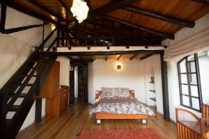 a bedroom with a bed and a wooden staircase at Sierra Alisos Hotel de Campo in Hacienda Tambillo Alto