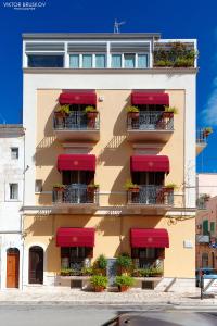 - un bâtiment avec des auvents rouges et des balcons dans l'établissement Sogno D'Epoca 1822, à Monopoli