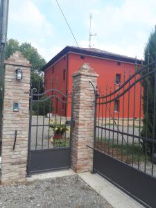 Castagnolo的住宿－Corte San Petronio，一座橙色的建筑,设有大门和砖柱