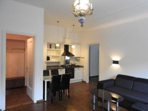een woonkamer en een keuken met een bank en een tafel bij Laisvės alėja in Kaunas