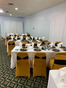 une salle remplie de tables et de chaises avec des nappes blanches dans l'établissement Budget Inn & Suites - Talladega, à Talladega