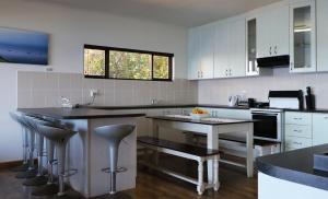 a kitchen with white cabinets and black counter tops at Anglers Paradise in Eersterivierstrand