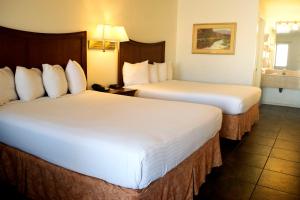 a hotel room with two beds and two lamps at Rio Del Sol Inn Needles in Needles