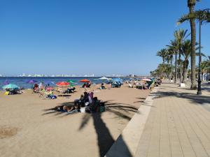 a beach with people laying on the sand and the ocean at Apartament Carina in Mar de Cristal