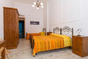 a bedroom with two beds with yellow sheets at Li Cuti B&B in Tiggiano