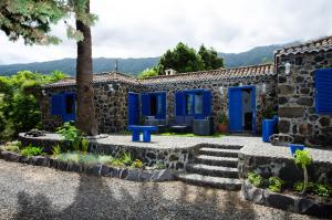 Casa de piedra con puertas y escaleras azules en Galguen Paradise in the island of stars. Villa. en Breña Alta