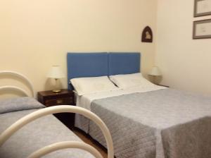 a bedroom with two beds and a blue headboard at Casa Adele in Lido di Camaiore