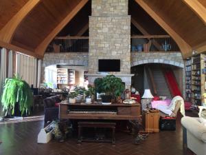 a living room with a piano and a fireplace at The Old Church B&B in Warner