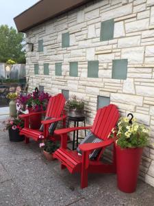 two red chairs and potted plants in front of a building at The Old Church B&B in Warner