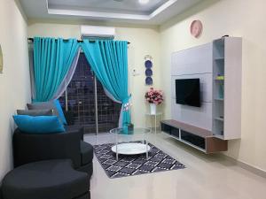uma sala de estar com cortinas azuis e uma televisão em Homestay Farah Tiara Duta Kondominium Ampang Selangor em Ampang