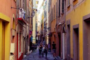 a group of people walking down a narrow alley at In the heart of Old Nice - 2min. from Cours Saleya and Promenade des Anglais in Nice