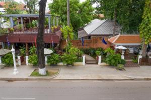 a building with a staircase leading into a courtyard at La Rivière d' Angkor Resort in Siem Reap