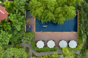 an overhead view of a pool with a person swimming in it at La Rivière d' Angkor Resort in Siem Reap