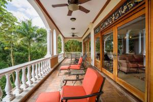 a porch with chairs and a ceiling fan at Pacifico Colonial Condominiums in Manuel Antonio