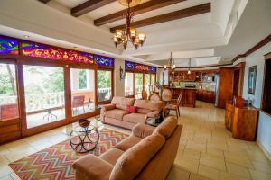 a living room with leather furniture and stained glass windows at Pacifico Colonial Condominiums in Manuel Antonio