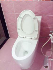 a bathroom with a white toilet in a pink room at Ocean View Resort - Koh Sichang in Ko Si Chang