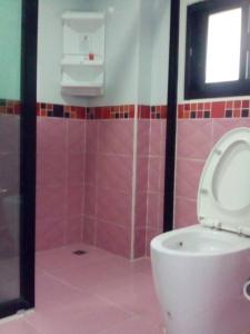 a bathroom with a toilet and a shower with pink tiles at Ocean View Resort - Koh Sichang in Ko Si Chang