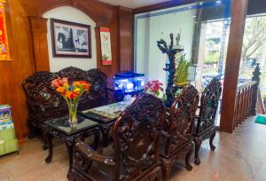 uma sala de jantar com uma mesa com cadeiras e flores em Hotel Kally Saigon em Ho Chi Minh