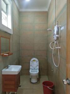 a bathroom with a toilet and a sink and a shower at Kundasang Guesthouse in Kundasang