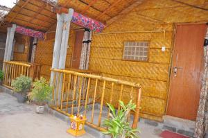 una casa de madera con una puerta delante de ella en Khushi Cottage en Hampi