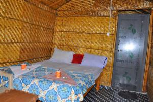 Habitación con cama en una cabaña de paja en Khushi Cottage, en Hampi