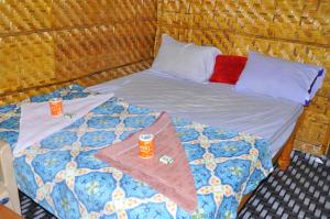 Una cama con dos bebidas encima. en Khushi Cottage en Hampi
