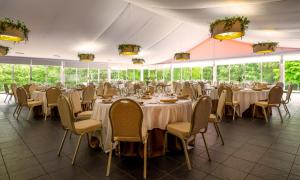 una sala banchetti con tavoli e sedie in una tenda. di Hotel Spa Attica21 Villalba a Villalba