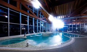 a large swimming pool in a building at night at Hotel Spa Attica21 Vilalba in Villalba