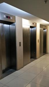 a row of elevator doors in a building at Mama Studio Inn in Kota Bharu