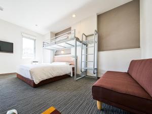 三原市Super Hotel Mihara Ekimae的酒店客房配有双层床和沙发。 更多30张照片