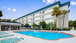 a hotel with a swimming pool in front of a building at Best Western Ocala Park Centre in Ocala