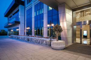 a building with tables and chairs outside of it at Clarion Hotel Istanbul Mahmutbey in Istanbul