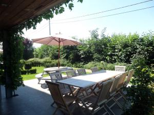 een tafel en stoelen met een parasol op een patio bij Bloesemhof in Alveringem