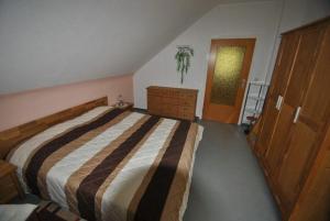 ein Schlafzimmer mit einem großen Bett und einer Kommode in der Unterkunft Haus Rehblick FeWo-OG-3 in Sankt Andreasberg