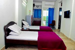 1 dormitorio con 2 camas y manta morada en Saanha Windtrip en Sylhet