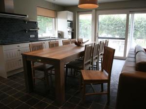 a kitchen with a large wooden table and chairs at Bloesemhof in Alveringem