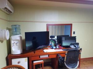 un escritorio con dos monitores y un ordenador. en Plus Motel en Gwangju
